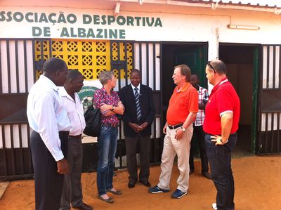 Inspektionsreise nach Mosambik; Besuch Sportplatz ADA; Koch mit vier mosambikanischen Herren und einer weißen Frau vor Vereinsheim von ADA