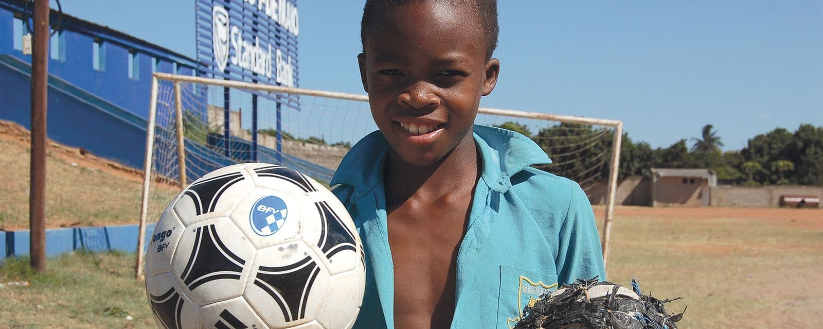 BFV-Sozialstiftung; mosambikanischer Junge mit normalem und selbstgebautem Fußball in der Hand