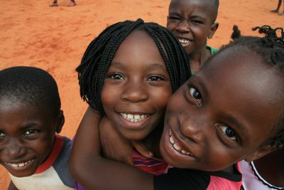 Vier lächelnde mosambikanische Mädchen schauen in die Kamera